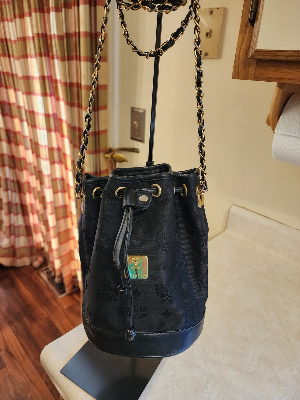 black vintage MCM Visetos canvas bucket bag featuring a gold chain strap
